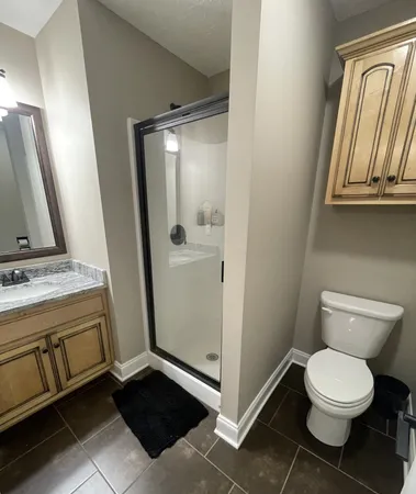 a bathroom with a granite countertop sink toilet and shower