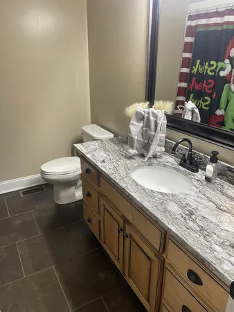 a bathroom with a granite countertop sink a toilet and a mirror