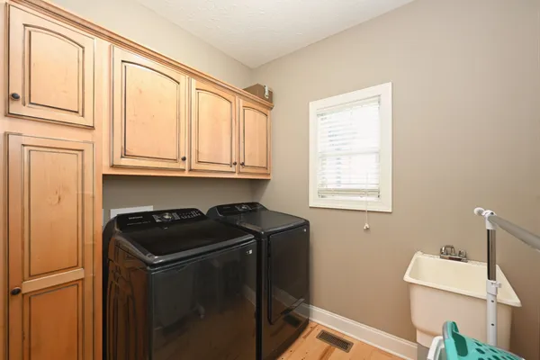 a utility room with sink dryer and washer