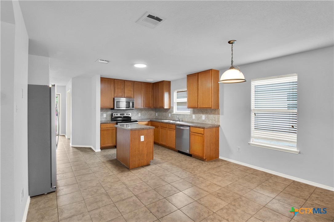117 Bashaw Loop Temple, TX 76502 - Photo 9 of 20 a kitchen with kitchen island granite countertop appliances cabinets and a counter top space