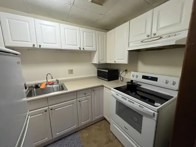 a kitchen with cabinets appliances and a sink