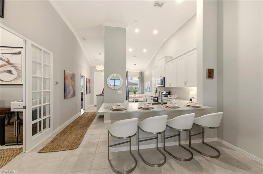 9365 Pocida Court, Unit 202 Naples, FL 34119 - Photo 6 of 40 a view of a dining room with furniture