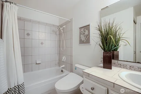 a bathroom with a sink a toilet a tub and shower