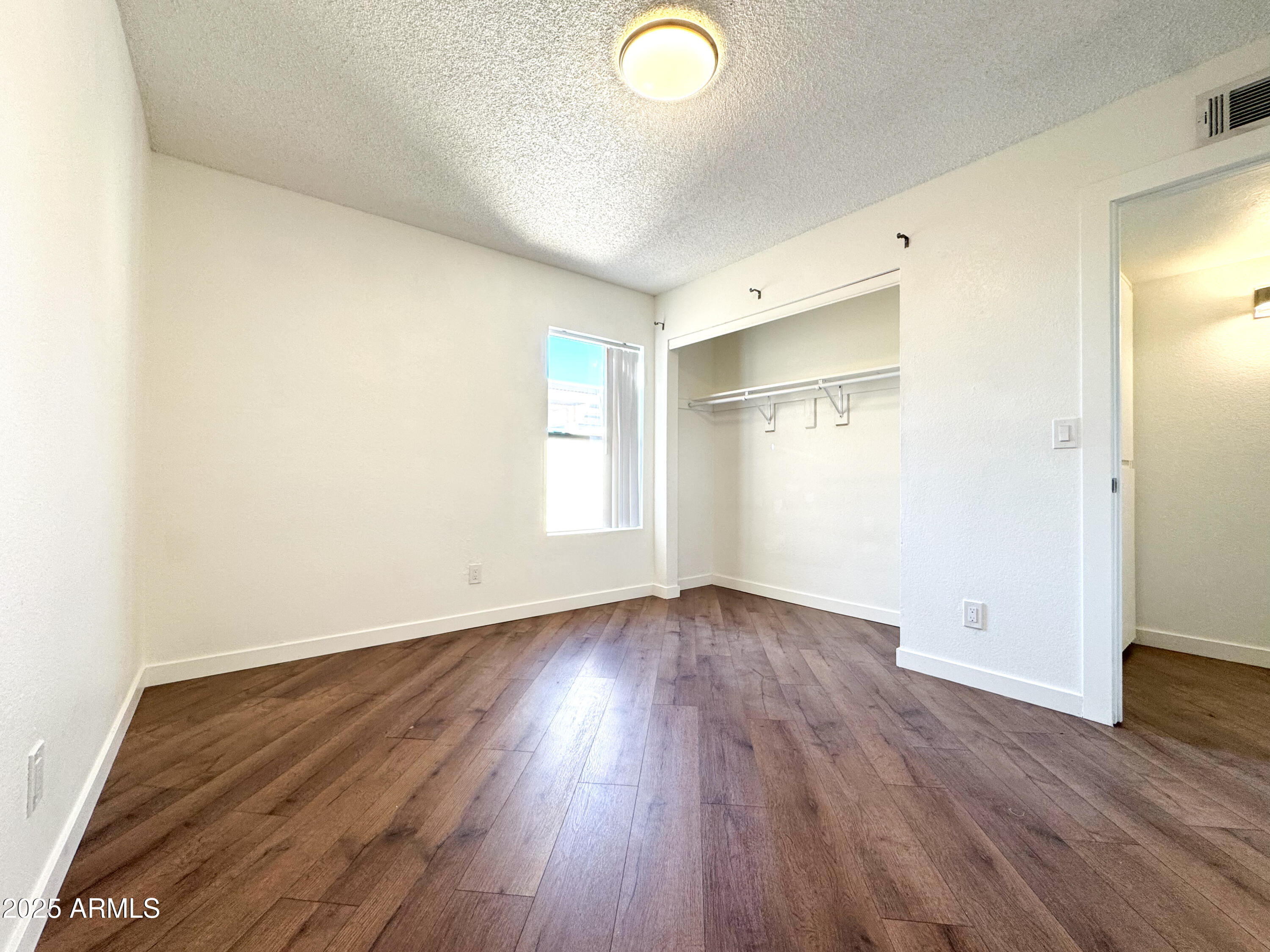 10215 North 8th Avenue, Unit 1 Phoenix, AZ 85021 - Photo 20 of 21 an empty room with wooden floor and windows