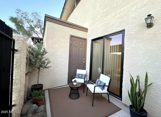 a porch with a bench and potted plants