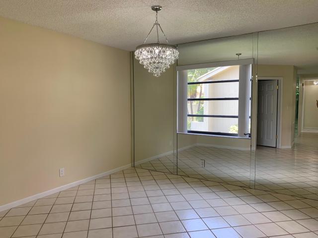 18065 Park Terrace Boca Raton, FL 33498 - Photo 9 of 20 an empty room with chandelier and windows