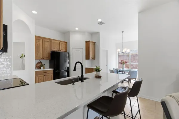 a kitchen with a table chairs and a refrigerator