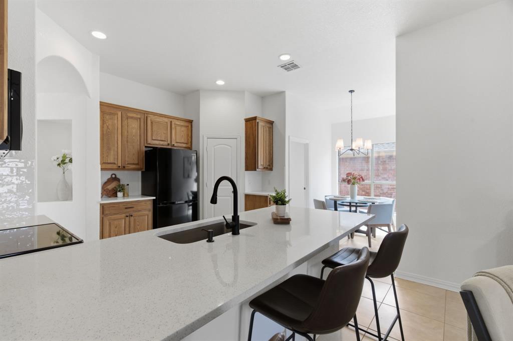 813 Chase Circle Hurst, TX 76053 - Photo 15 of 40 a kitchen with a table chairs and a refrigerator