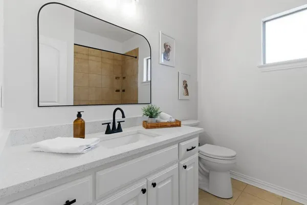 a bathroom with a toilet sink and mirror