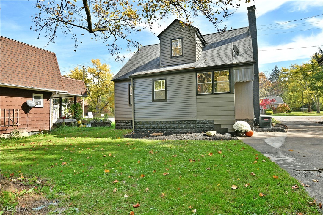 Back of property with central AC and a yard