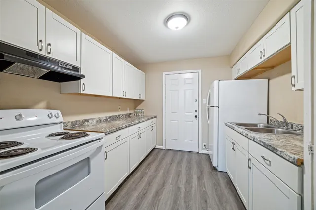 a kitchen with granite countertop cabinets stainless steel appliances and wooden floor