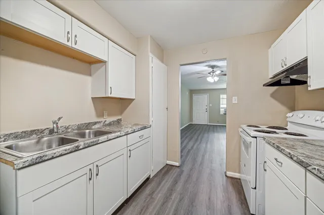 a kitchen with a sink cabinets and wooden floor
