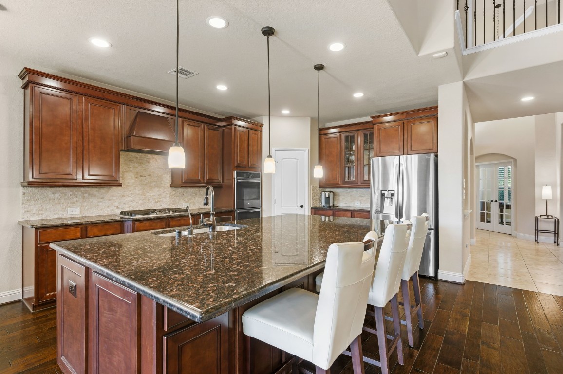 10 Waterfall Way The Woodlands, TX 77375 - Photo 16 of 45 a kitchen with stainless steel appliances granite countertop a kitchen view and chairs