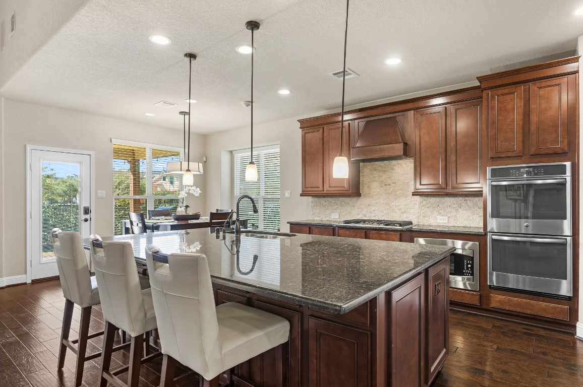10 Waterfall Way The Woodlands, TX 77375 - Photo 17 of 45 a kitchen with kitchen island a large counter top space appliances and a center island