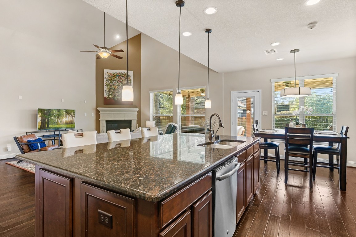 10 Waterfall Way The Woodlands, TX 77375 - Photo 18 of 45 a kitchen with granite countertop center island wooden floor and stainless steel appliances