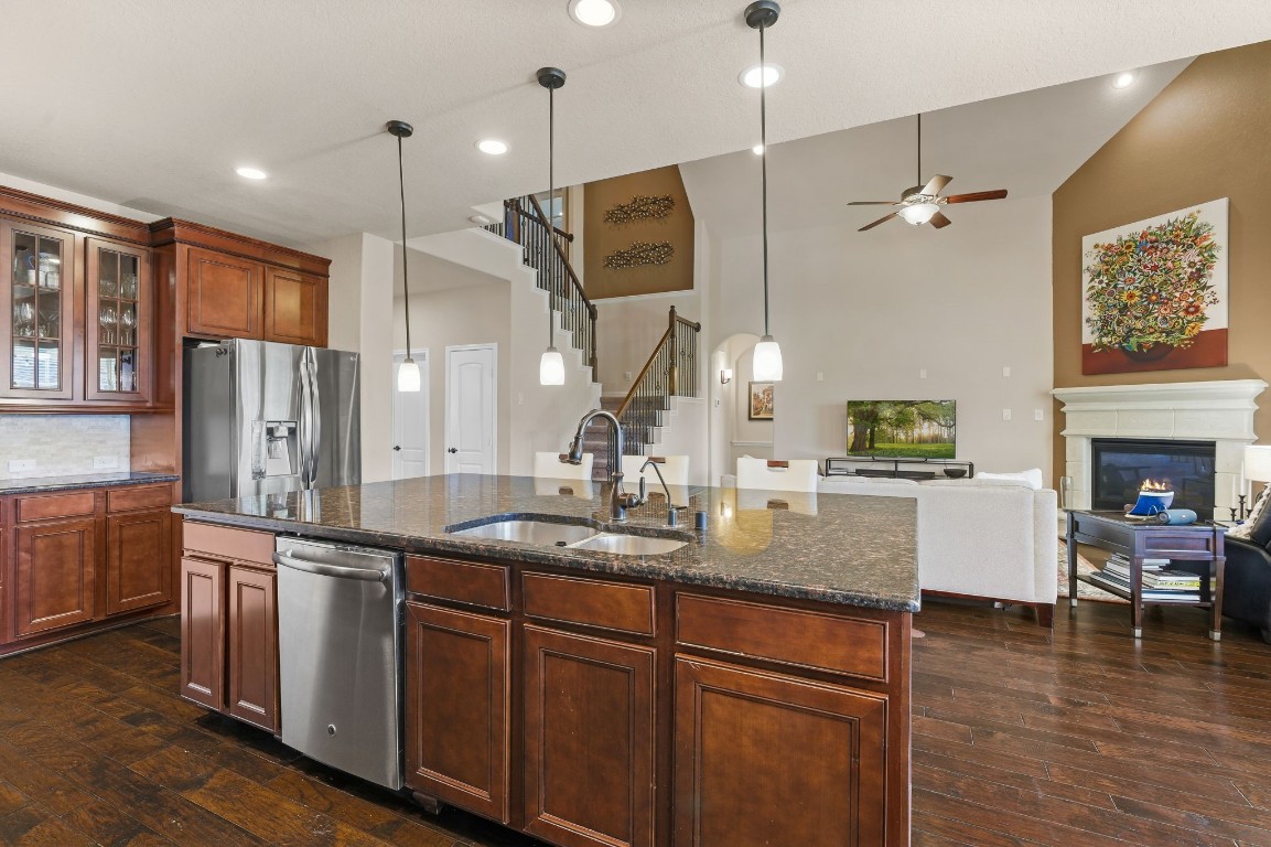 10 Waterfall Way The Woodlands, TX 77375 - Photo 19 of 45 a kitchen with kitchen island granite countertop a sink appliances and cabinets
