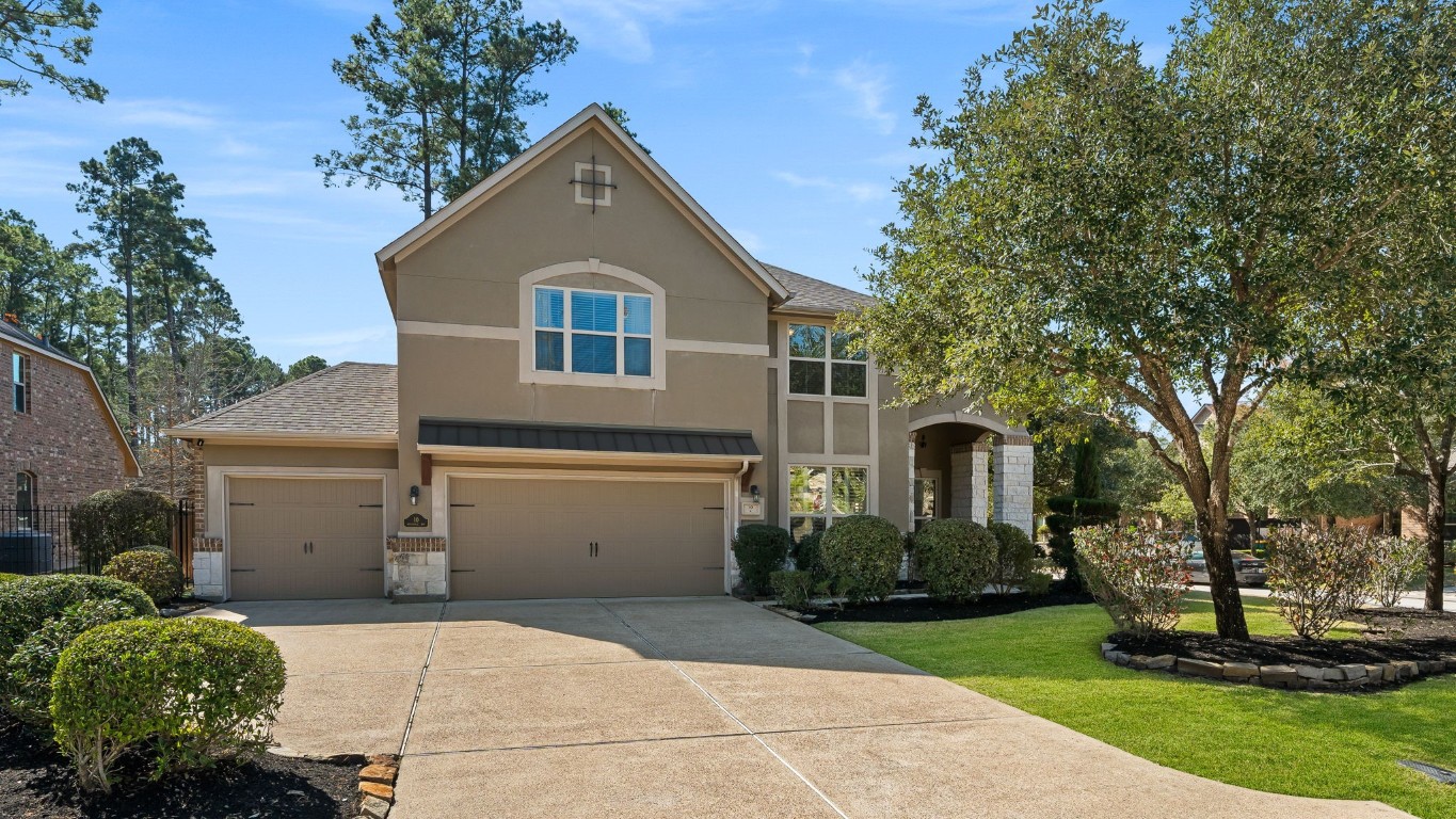 10 Waterfall Way The Woodlands, TX 77375 - Photo 2 of 45 a front view of a house with a garden and trees