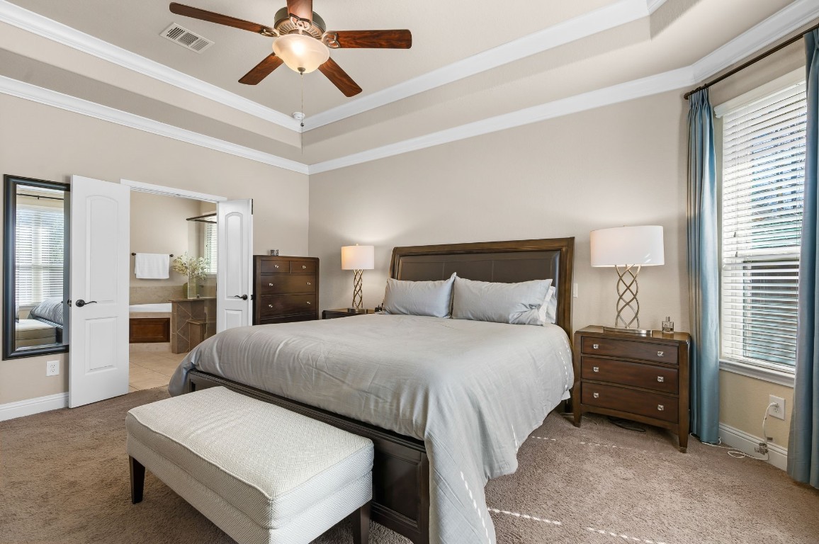 10 Waterfall Way The Woodlands, TX 77375 - Photo 22 of 45 a bedroom with a bed and a chandelier