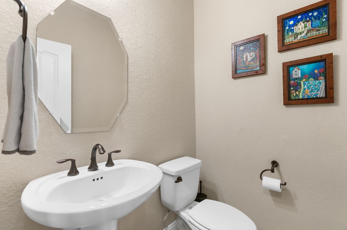 10 Waterfall Way The Woodlands, TX 77375 - Photo 27 of 45 a bathroom with a toilet a sink and mirror