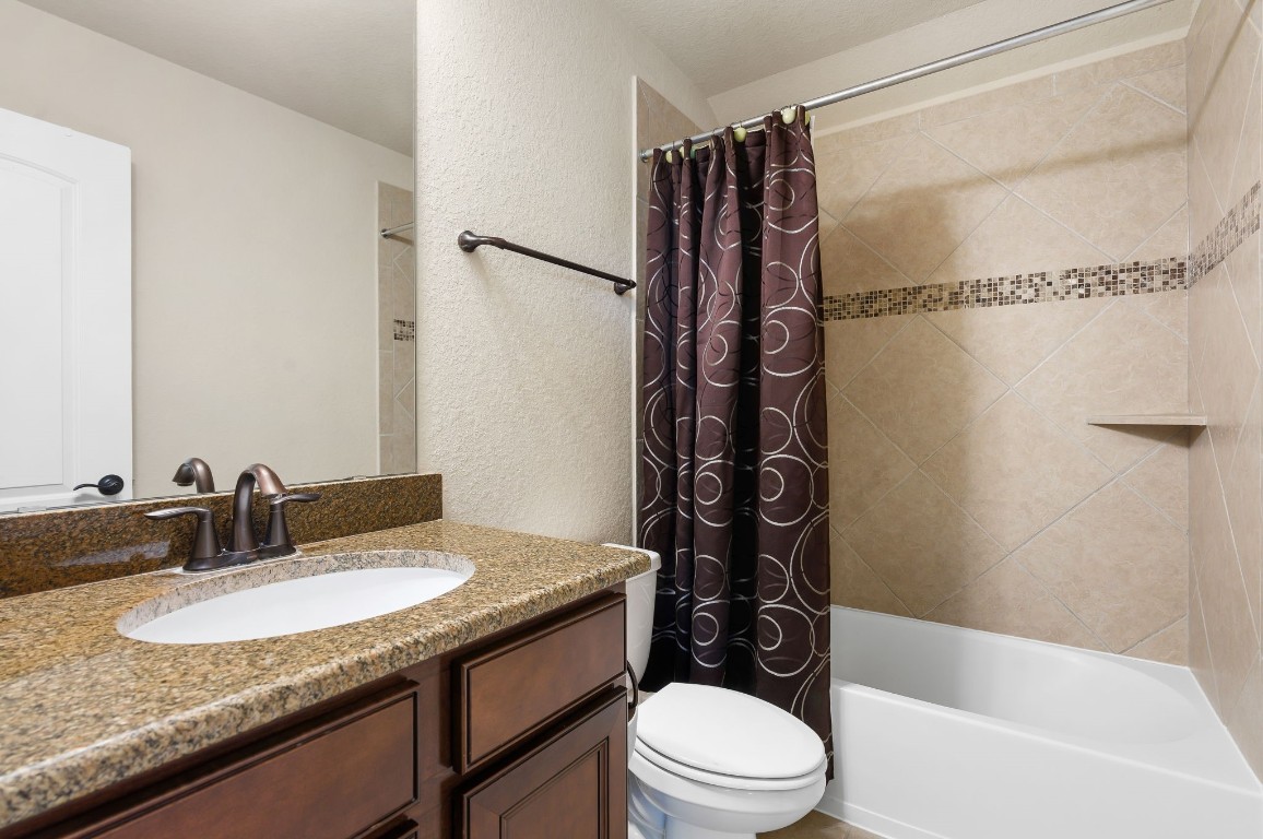 10 Waterfall Way The Woodlands, TX 77375 - Photo 37 of 45 a bathroom with a granite countertop sink toilet and shower