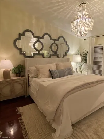 a bedroom with a bed and a chandelier