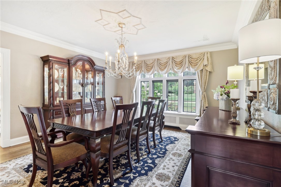 875 Mayfair Road Akron, OH 44303 - Photo 12 of 40 Dining space with hardwood / wood-style flooring, a chandelier, and ornamental molding