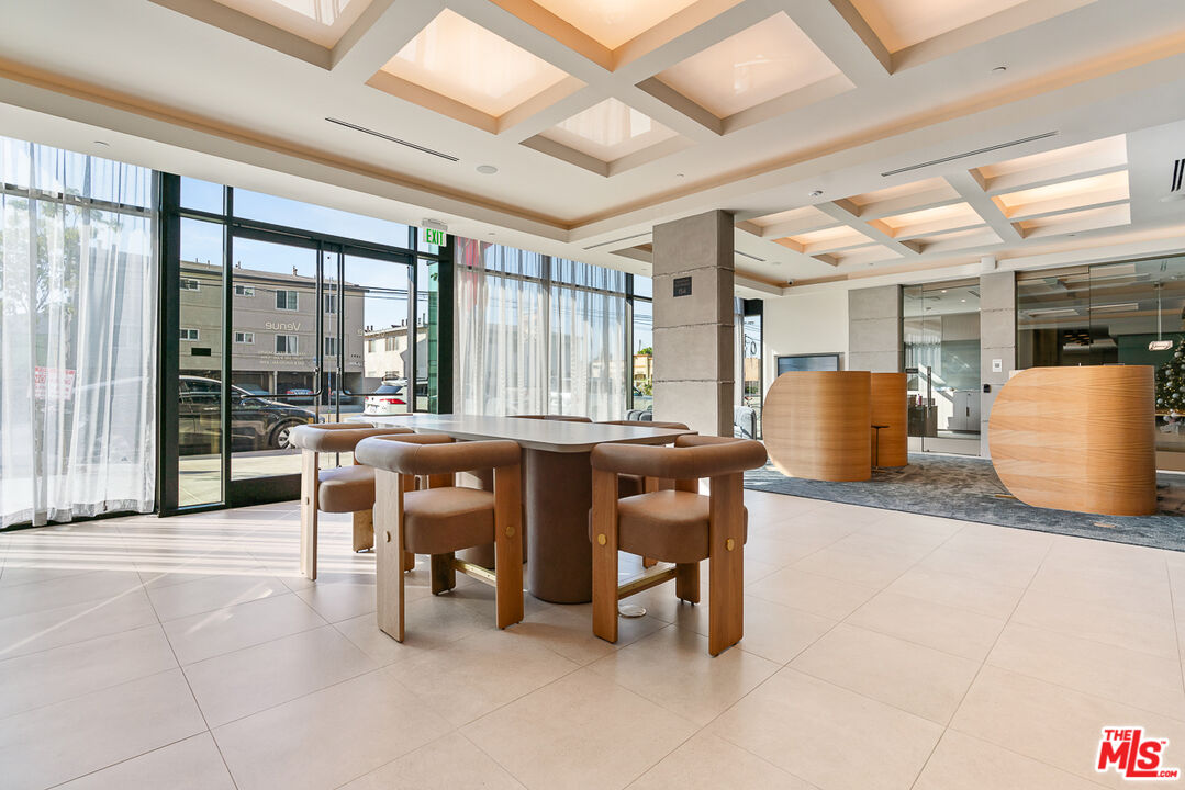 3667 Keystone Avenue, Unit 526 Los Angeles, CA 90034 - Photo 27 of 30 a dining hall with stainless steel appliances kitchen island granite countertop a table and chairs