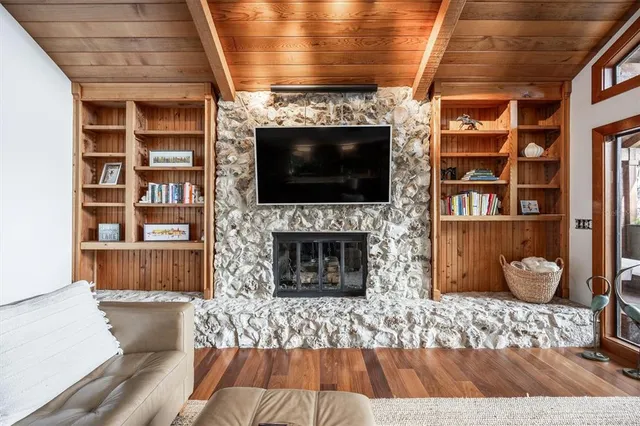 a spacious bedroom with a large bed a chandelier and dresser