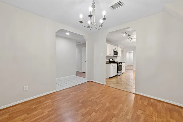 wooden floor in an empty room with a kitchen
