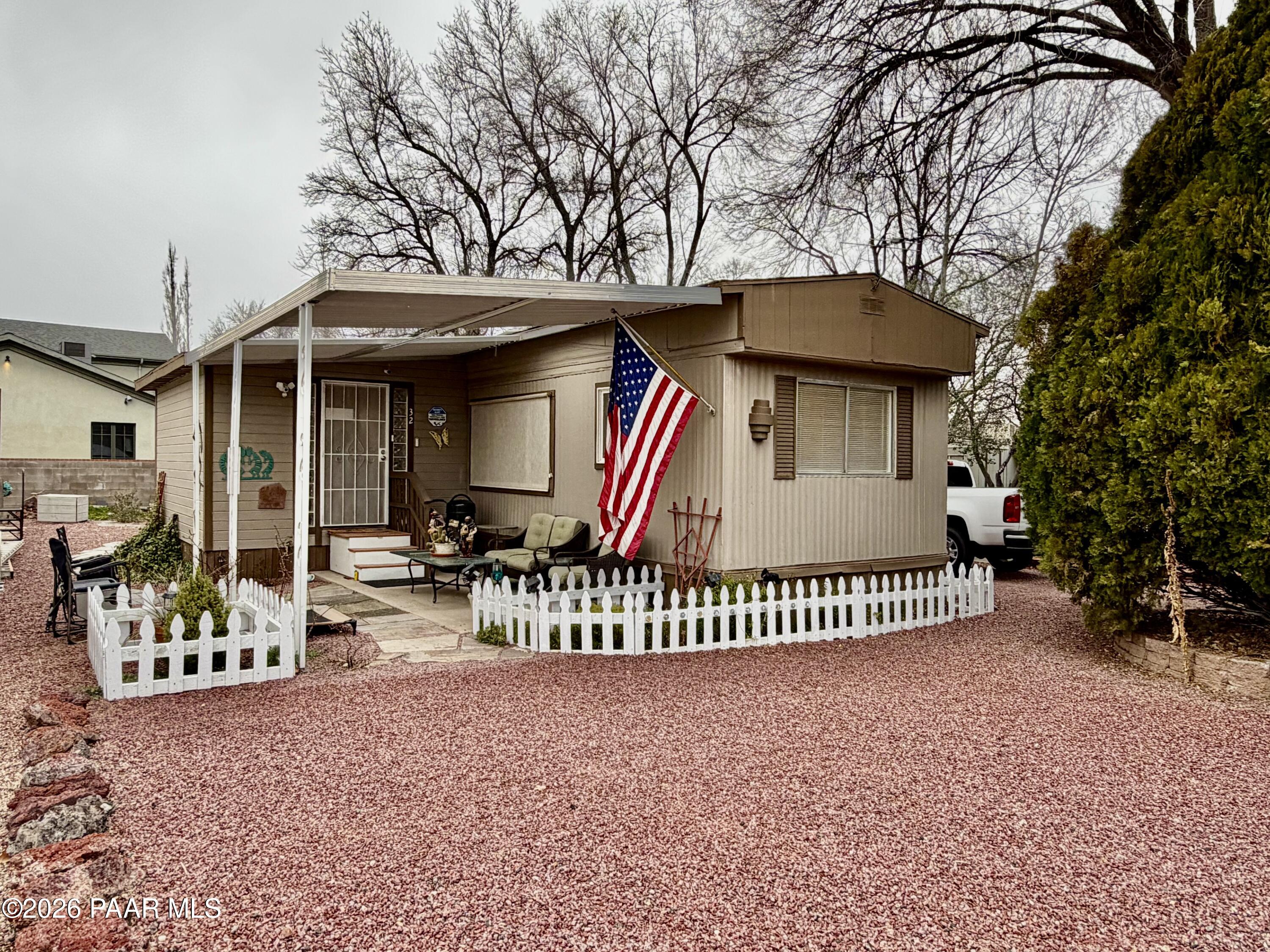 a view of a house with a small yard and furniture