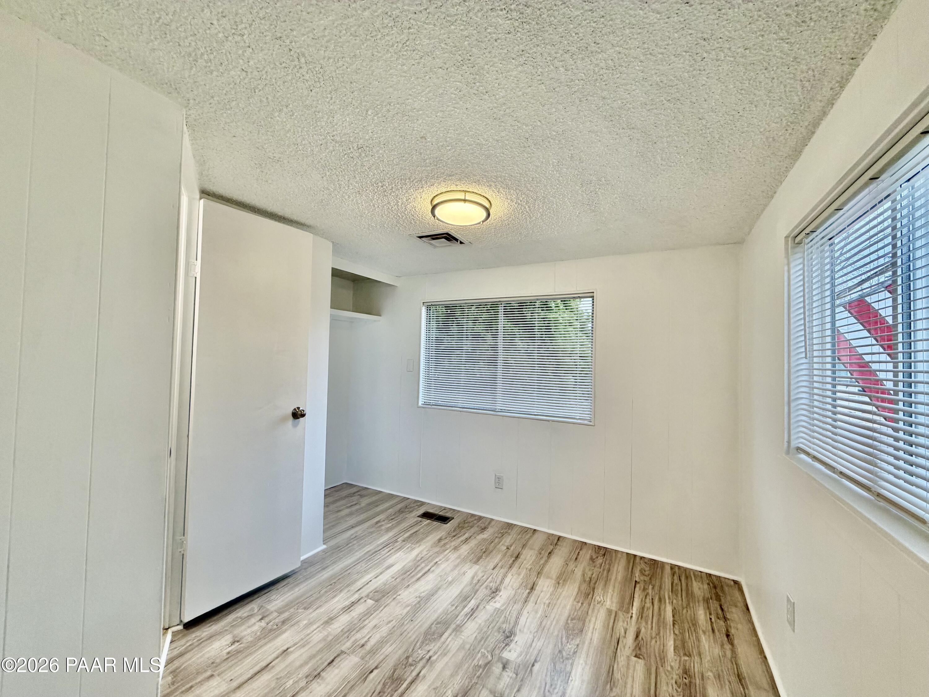 837 Division Street, Unit 32 Prescott, AZ 86301 - Photo 15 of 21 a view of an empty room with wooden floor and a window