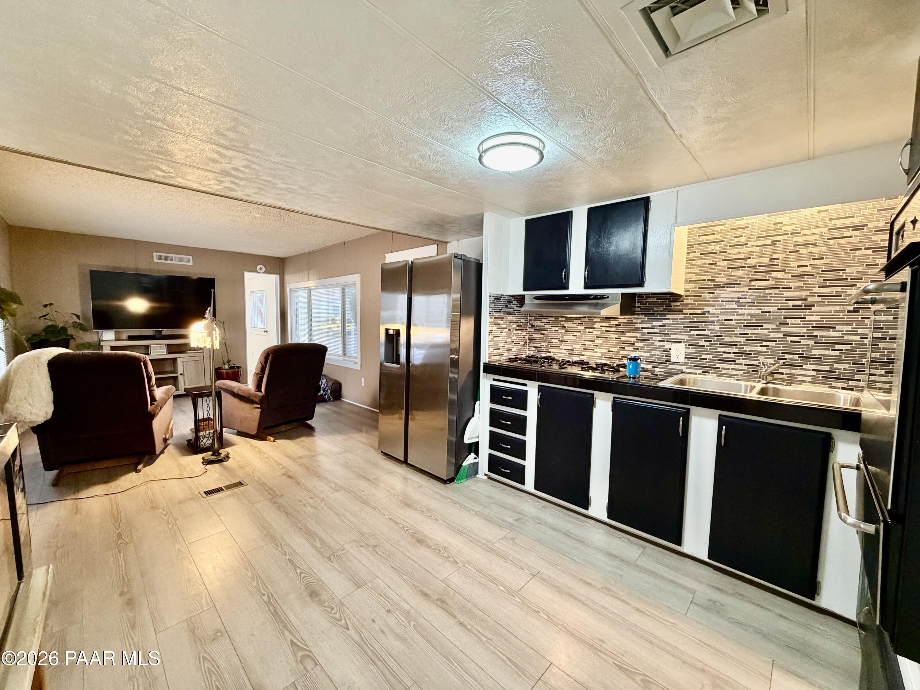 837 Division Street, Unit 32 Prescott, AZ 86301 - Photo 3 of 21 a kitchen with stainless steel appliances kitchen island granite countertop a refrigerator stove microwave and sink