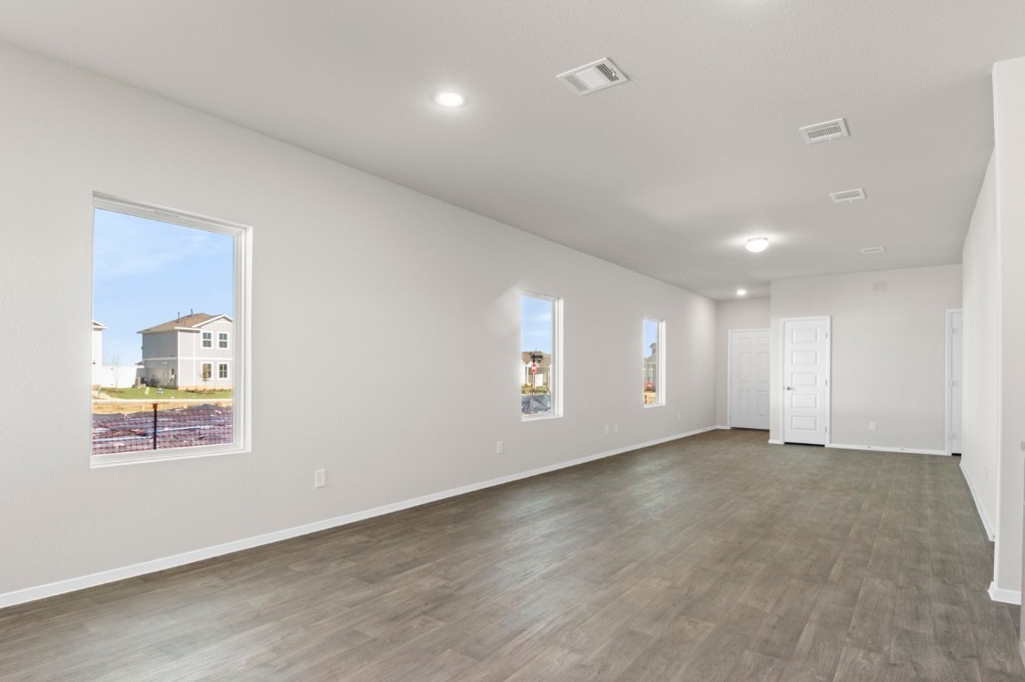 108 Summer Drive Elgin, TX 78621 - Photo 16 of 35 an empty room with wooden floor and windows