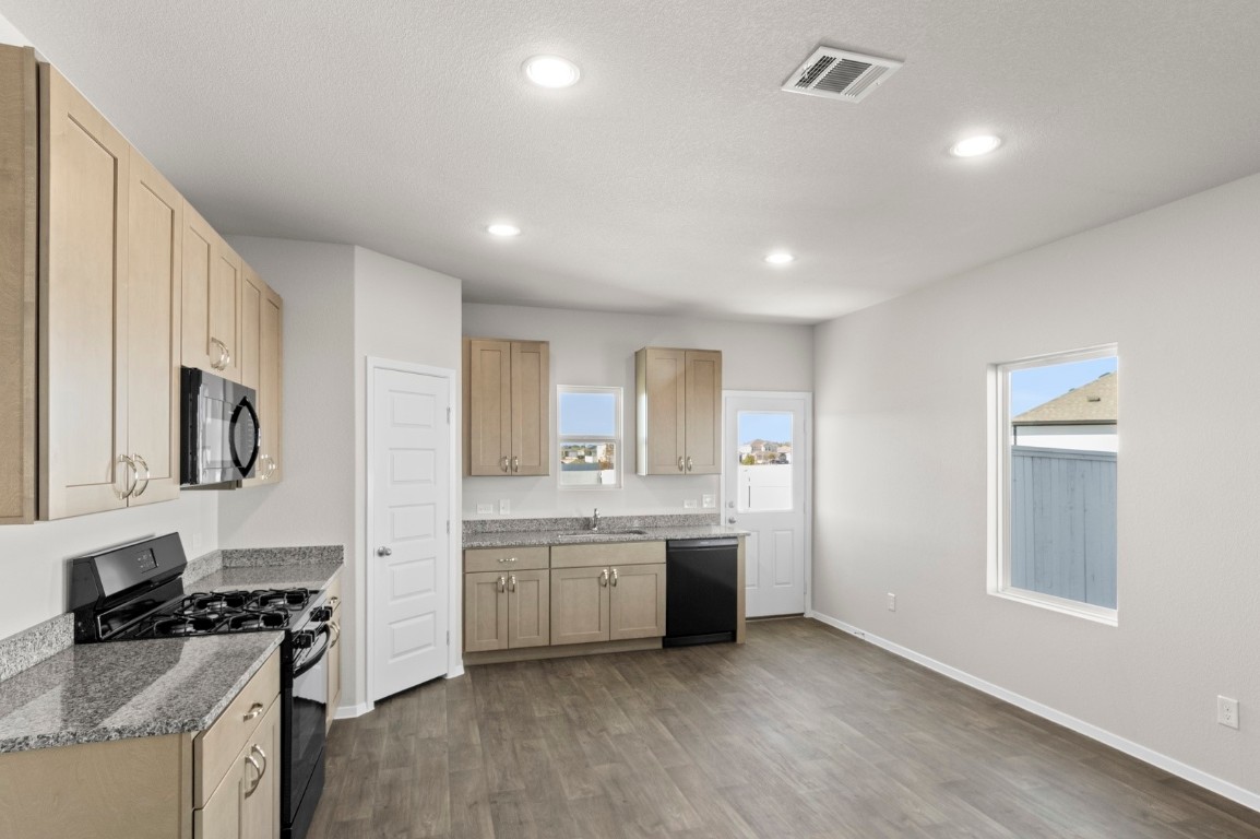 108 Summer Drive Elgin, TX 78621 - Photo 19 of 35 a kitchen with a sink stove and cabinets
