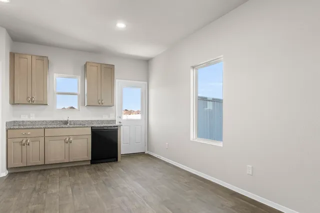 a kitchen with granite countertop a sink stove and cabinets