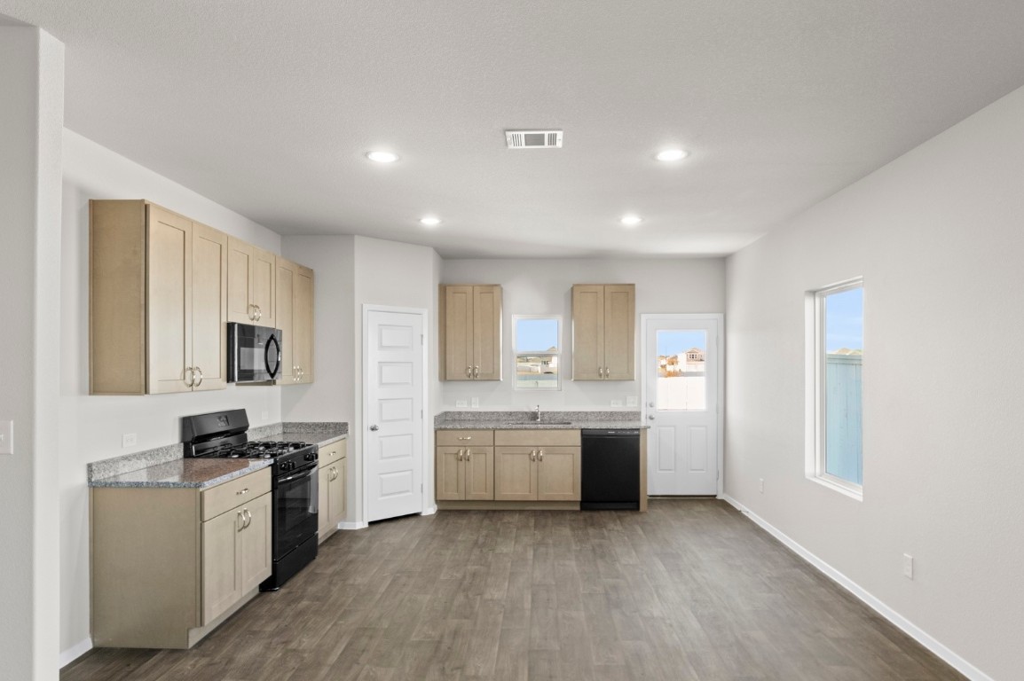 108 Summer Drive Elgin, TX 78621 - Photo 20 of 35 a large kitchen with kitchen island a sink stainless steel appliances and cabinets