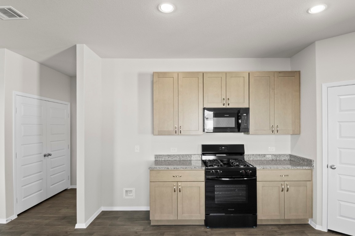 108 Summer Drive Elgin, TX 78621 - Photo 22 of 35 a kitchen with white cabinets and appliances