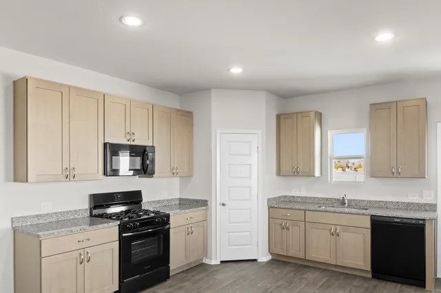 a kitchen with granite countertop white cabinets and stainless steel appliances