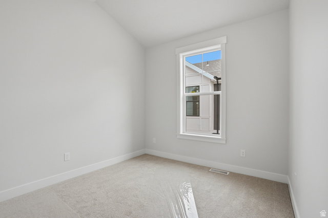 7338 South Seven Tree Lane, Unit 75 Midvale, UT 84047 - Photo 19 of 30 Spare room featuring light carpet and vaulted ceiling