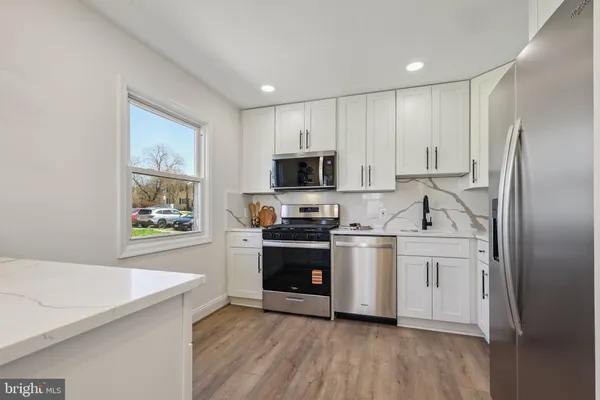 a kitchen with stainless steel appliances a stove a sink and a refrigerator