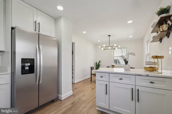 a kitchen with kitchen island white cabinets and stainless steel appliances