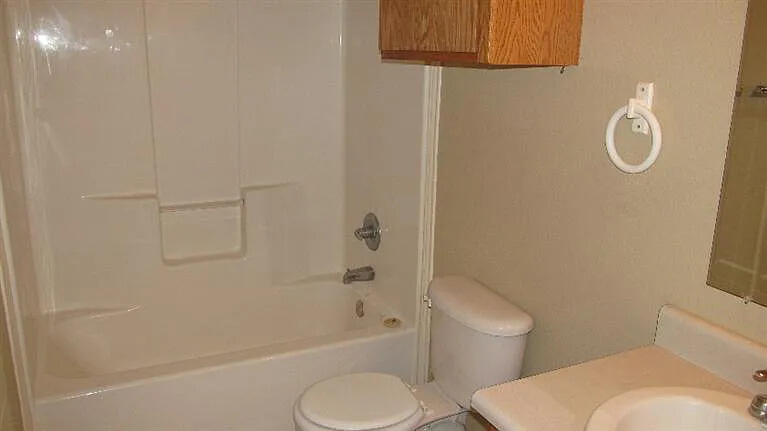 914 82nd Street, Unit B Lubbock, TX 79423 - Photo 3 of 8 a white toilet sitting next to a bath tub