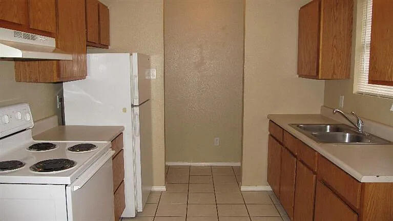 914 82nd Street, Unit B Lubbock, TX 79423 - Photo 7 of 8 a kitchen with a sink stove and refrigerator