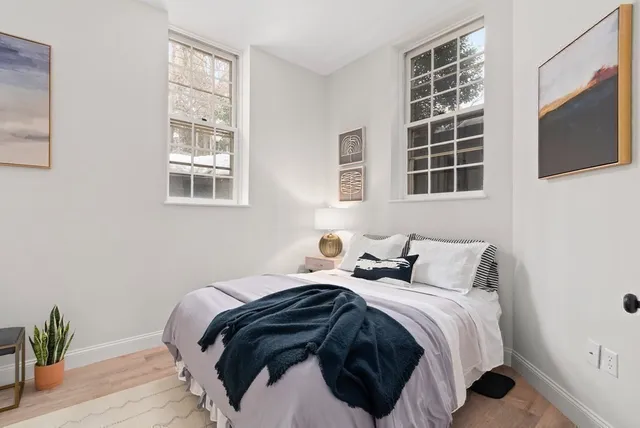 a bedroom with a bed and flat tv screen on the dresser