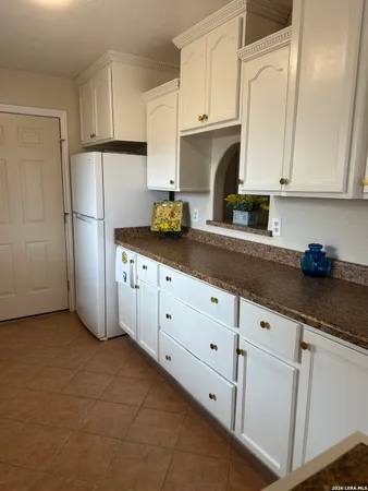 a kitchen with granite countertop white cabinets and stainless steel appliances