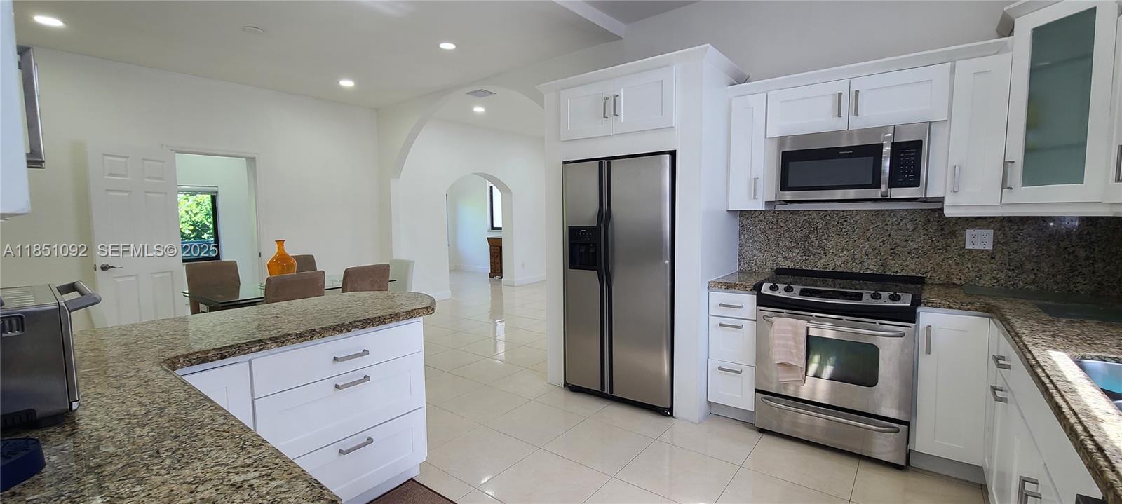 1721 Southwest 24th Terrace Miami, FL 33145 - Photo 25 of 80 a kitchen with stainless steel appliances granite countertop a stove a microwave and a refrigerator