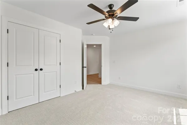 a bedroom with a bed and a ceiling fan