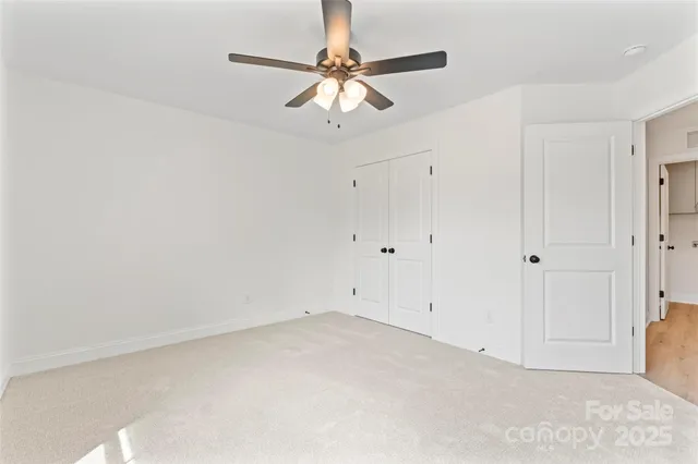a bedroom with a bed and a ceiling fan