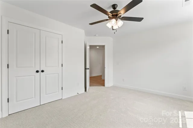 a spacious bedroom with a bed and a chandelier