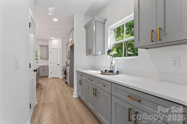 a kitchen with a sink and wooden floor
